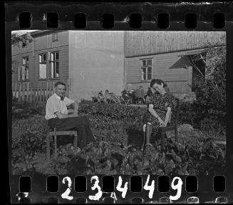 A couple seated on chairs among garden beds