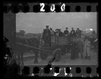 Jewish policemen standing beside a horse-drawn wagon carrying residents being deported from the ghetto