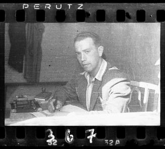 Man sitting at a desk with pen and paper