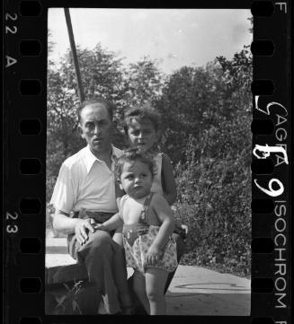 A man with a boy and a baby, seated