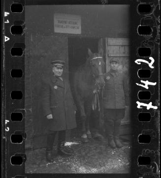 Workers of the Transport Department standing outside the entrance to a horse stable