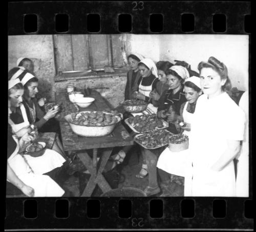 Women in the kitchen peeling potatoes