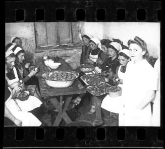 Women in the kitchen peeling potatoes
