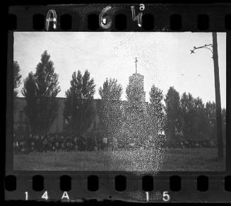 Massive deportation of residents from the Lodz ghetto walking by a church
