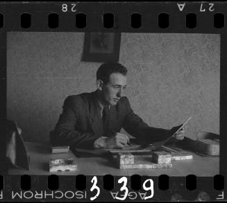 A member of the ghetto administration looking over documents at his desk