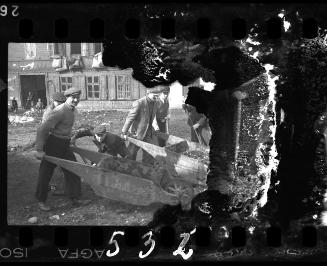 Workers pushing wheelbarrows filled with rubble