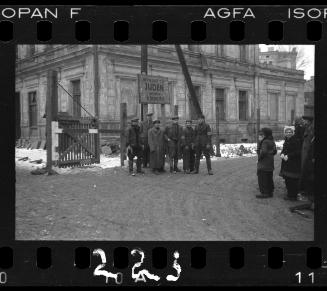 Lodz Ghetto liberated, residents standing freely at restricted Juden gate