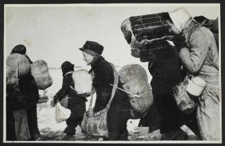 Boy in cap, with satchel and sack tied to back, walking with winter deportation crowd -side-profile