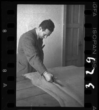 Man cutting fabric in a workshop in the ghetto