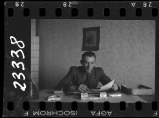 A member of the ghetto administration looking over documents at his desk