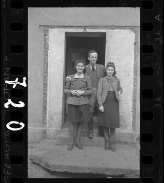Kitchen manager standing in front of a doorway with two women