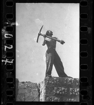 A man holding a pickaxe (side view)