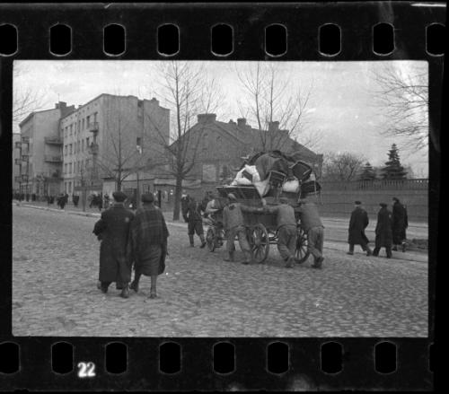 Residents hauling chairs and other belongings on a cart through the ghetto