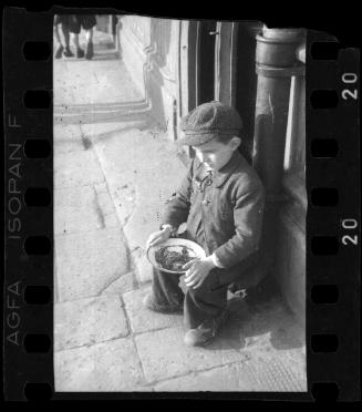 A little boy on the street with food plate