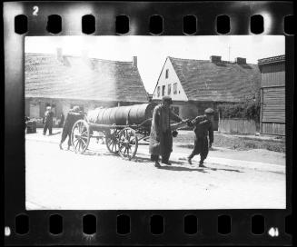 Fecal workers hauling a sewage collecting tank mounted on a wagon through the ghetto