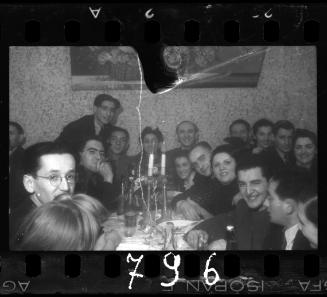 The bride and groom (sitting, centre) celebrate with friends at their wedding reception in the ghetto