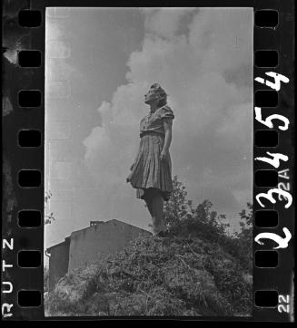 Portrait of Stefania Schoenberg, standing in profile on a mound