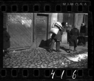 Man walking down the street with a bundle on his back