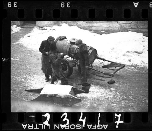 Fecal workers standing beside a sewage collecting wagon