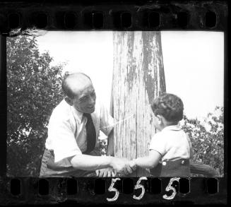 Man holding a boy by his hand