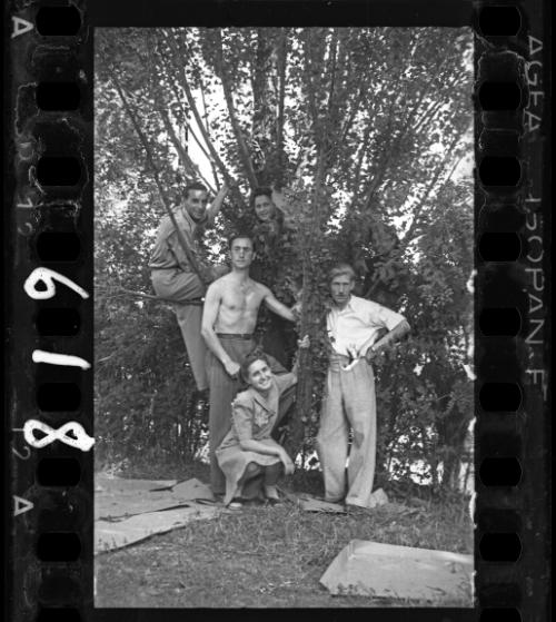 Residents, posing with a vine covered tree