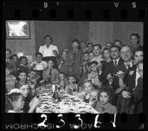 Children and parents gathered around the table at a children's party