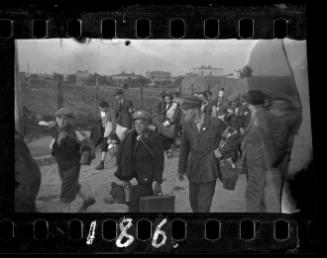 Jewish policemen and residents being deported from the ghetto with their belongings