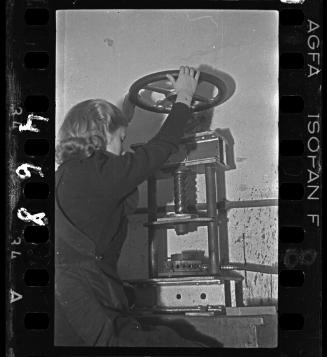Female worker operating roll press
