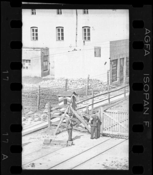 Two Jewish policemen beside an entry gate to the ghetto