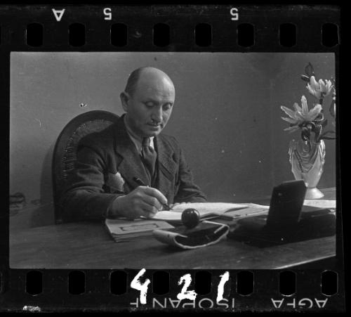 A member of the ghetto administration sitting at a desk with a pen and notebook