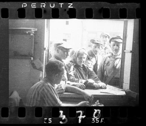 Residents gathered outside of a clerk window receiving papers