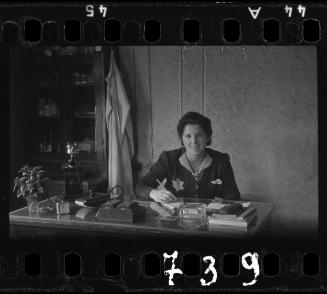 Jewish woman sitting at a desk with a pen and notepad