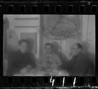 Three men sitting around a table