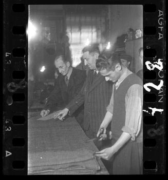 Men cutting fabric in a workshop ("ressort") in the ghetto