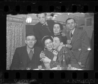 Woman wearing policeman's hat, celebrating with friends