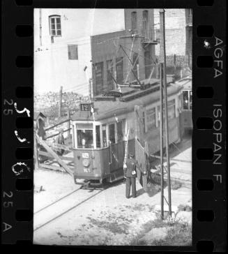 Jewish policeman opening an entry gate to the ghetto for a streetcar