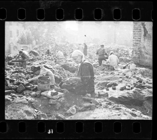 Woman sitting in the ruins of the synagogue on Wolborska Street, destroyed by the Germans in 1939