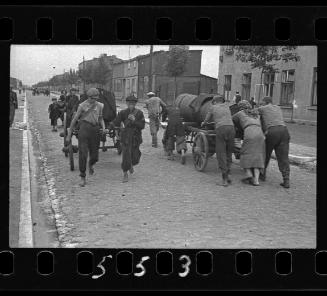 Fecal workers hauling a sewage collecting tank mounted on a wagon through the ghetto