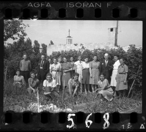 Residents standing in a vegetable garden, with church on Wawelska Street in the background