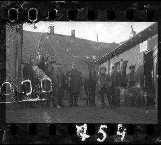 Workers of the Transport Department, standing with horses, outside a stable in the ghetto