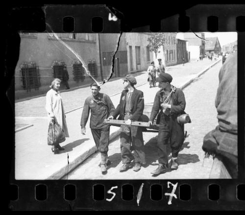 Workers hauling a cart through the street in the ghetto