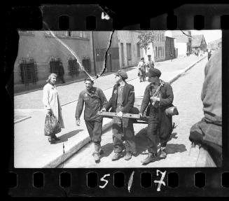Workers hauling a cart through the street in the ghetto