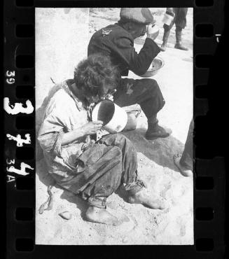 Man and woman eating from pot and pail on street corner