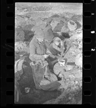 Young boy and two women digging a pit in search of provisons