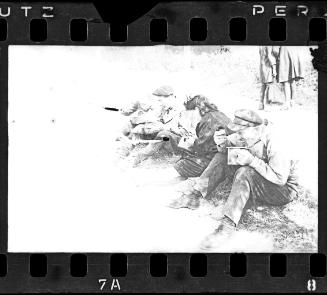 Residents sitting on roadside eating from pails