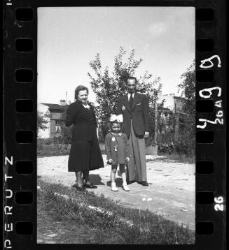 Family with a little girl posing in front of ghetto building