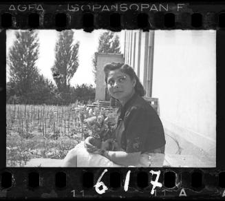 Young woman holding a bouquet of flowers, looking sideways