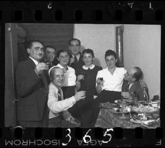 Residents hold up their glasses in celebration at a party