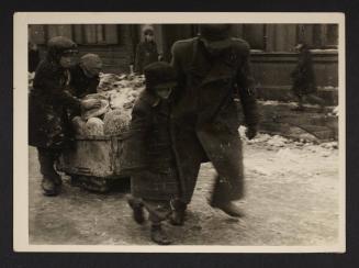 Man and boys moving cart with bread