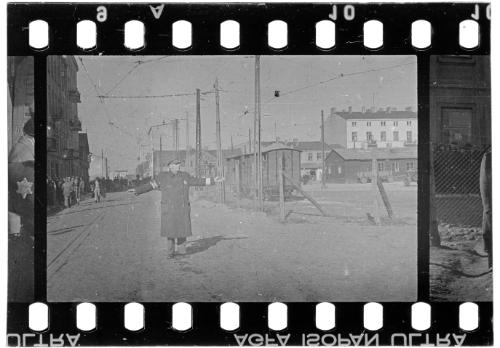 Jewish policeman directing people traffic of residents carrying belongings through the ghetto